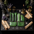Seven-piece green gua sha set on an ancient enchanted apothecary altar